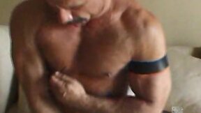 Muscular gay guy strokes it
