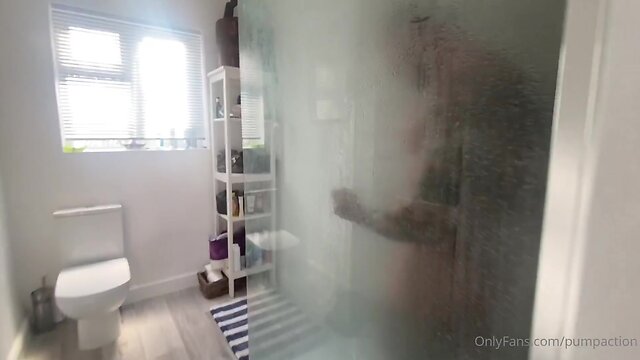 Muscular man showering in slow motion